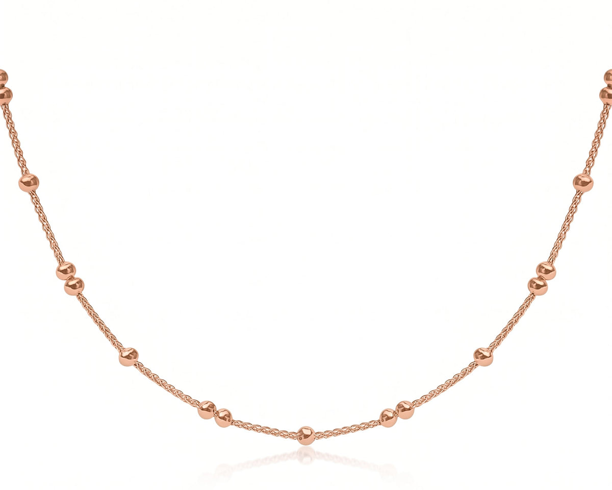 A Dainty Gold Beaded Wheat Chain Necklace with small, evenly spaced spherical beads, displayed against a clean white background with a subtle reflection.