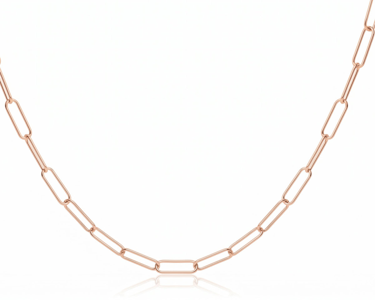 A rose gold paperclip chain necklace displayed in a U-shape against a clean white background with a subtle reflection below.