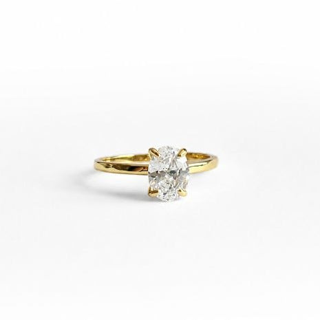 A yellow gold plated silver ring with a single oval-cut clear gemstone, shown on a plain white background.