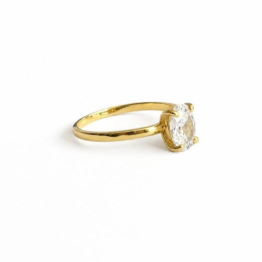 A yellow gold plated silver solitaire engagement ring with a round brilliant-cut diamond, shown on a plain white background with black letterbox bars on the left and right.