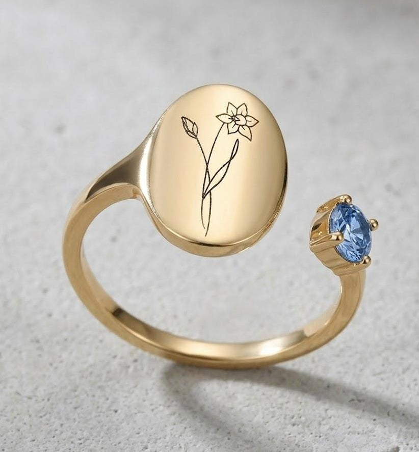 Close-up of engraved daffodil flower on a gold plated silver open signet ring