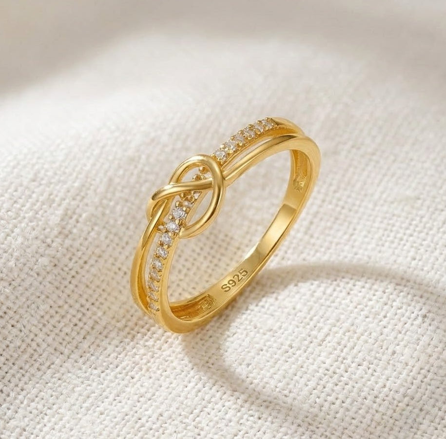 Gold Plated Silver Knot Purity Ring – "Tie the Knot" Promise Ring on a white background on a light fabric background