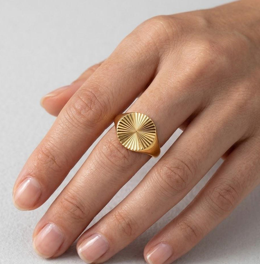 Modern sunray statement ring on a woman's hand, vintage-inspired gold jewelry
