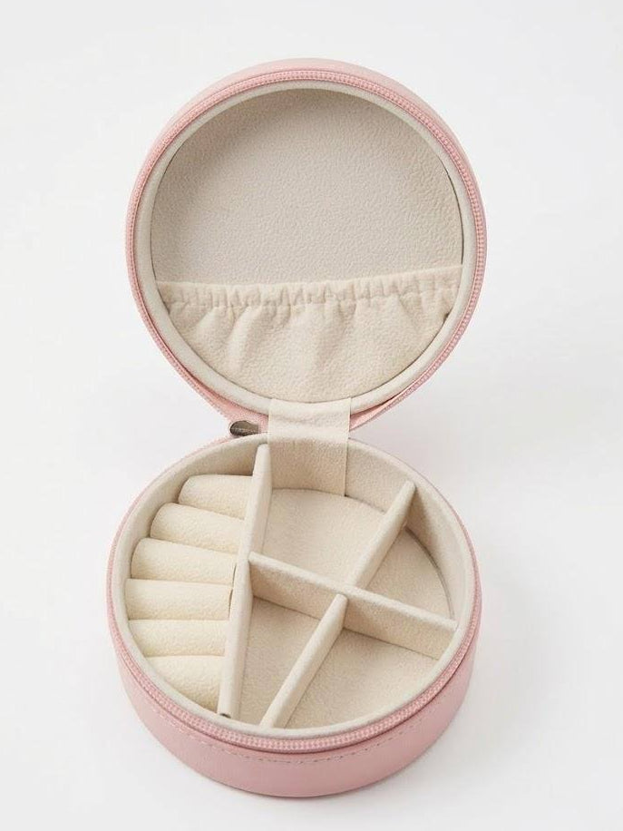 Round pink jewelry case with beige interior on a white background