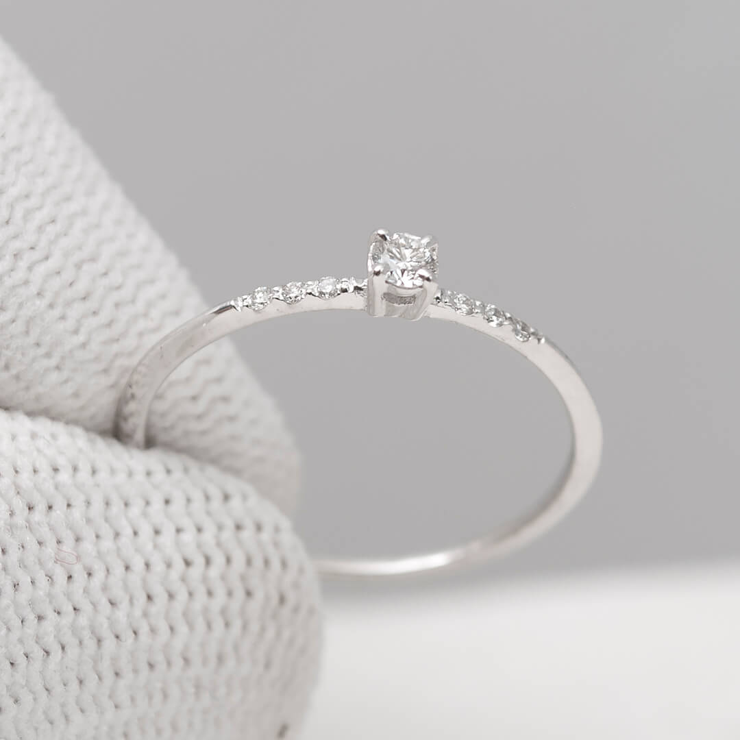 Minimalist 14K gold promise ring on gray background