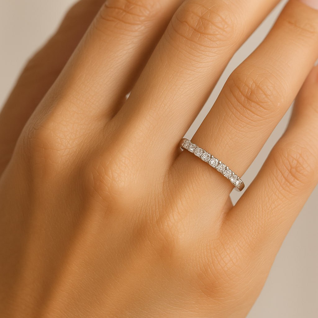 Close-up of a hand wearing a Silver ring with small 11 moissanites on a light gray background.