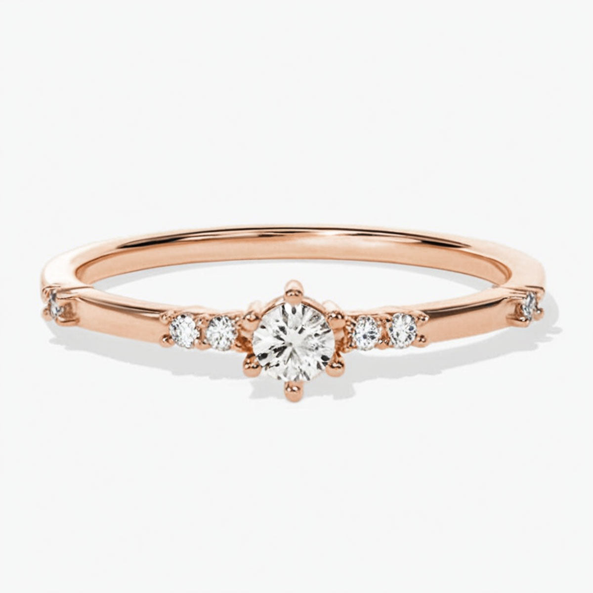 moissanite promise ring in 14K rose gold on white background