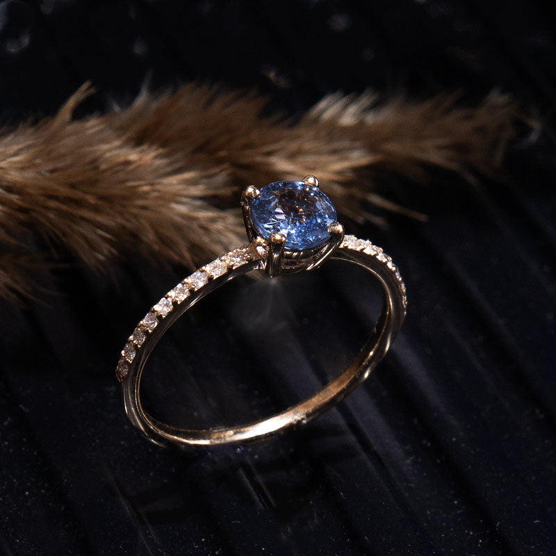 Blue Promise Ring in 14k yellow gold at black background