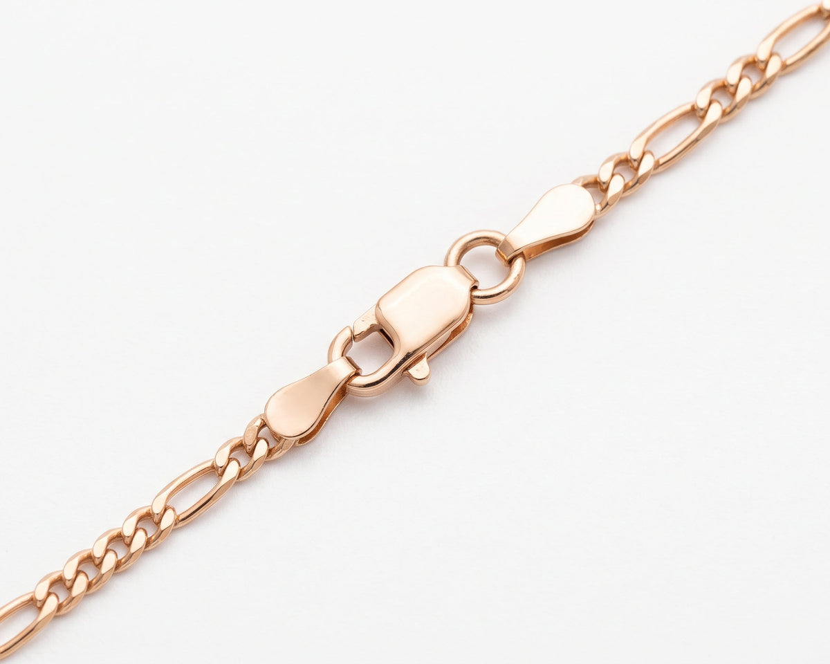 A close-up of a  Gold Vermeil Figaro Chain Necklace necklace displayed in a curved shape against a clean white background.with a lobster clasp, shown on a clean white background.