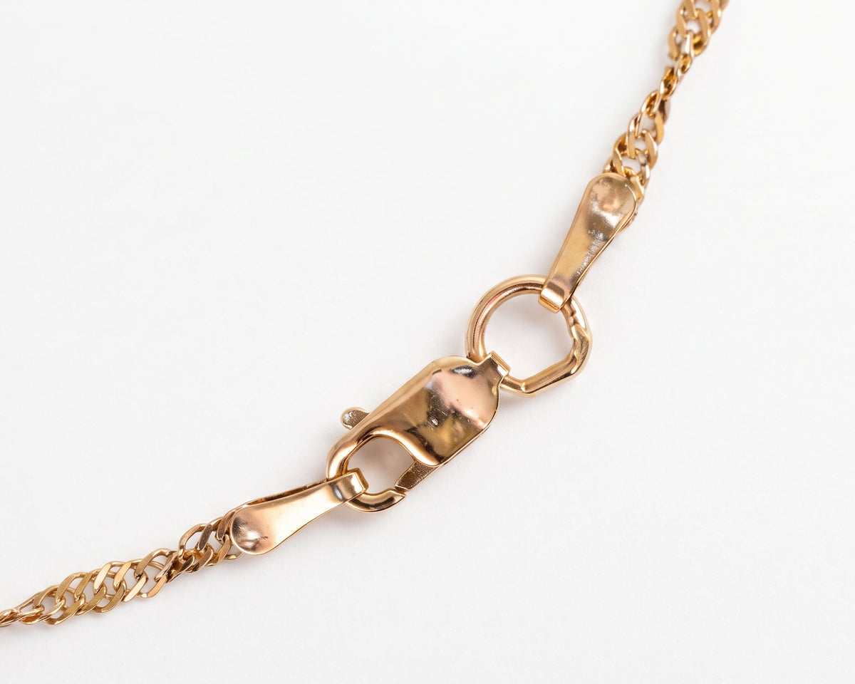 A close-up of a delicate Dainty Gold Singapore Chain Necklace showing a lobster clasp and ring connector on a clean white background.