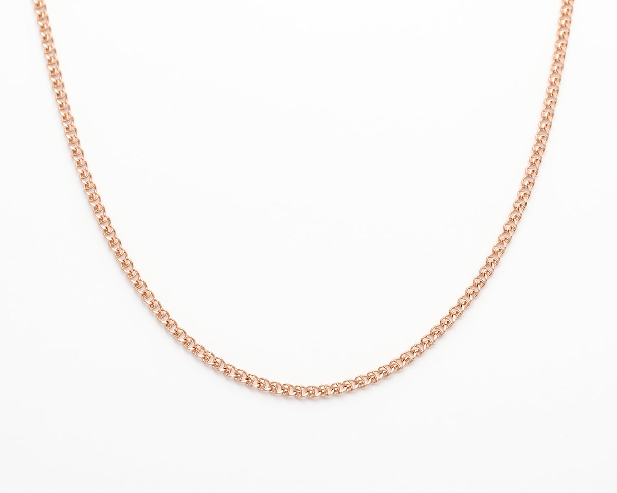 A delicate Gold Vermeil Heart Chain Necklace displayed in a curved shape against a solid white background.