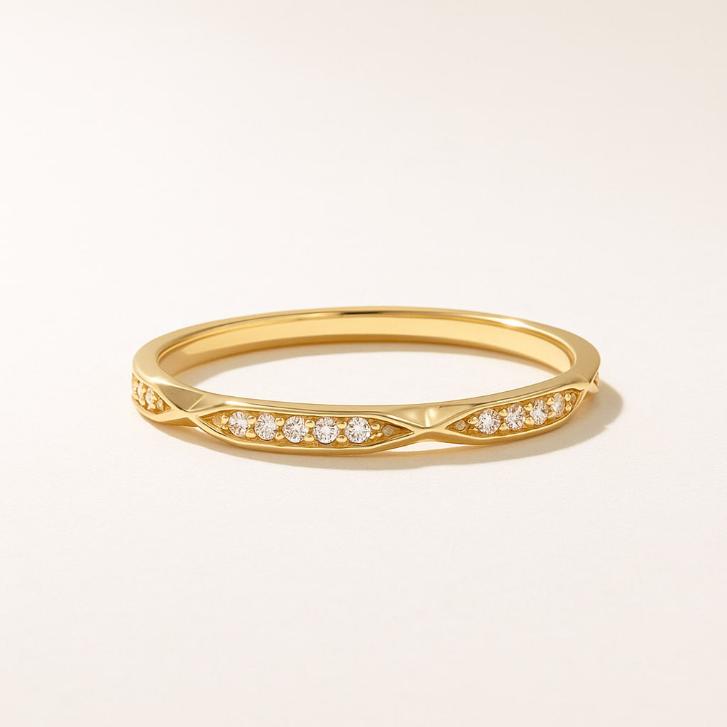 Classic Yellow Gold Eternity Wedding Band with small diamonds on a light beige background
