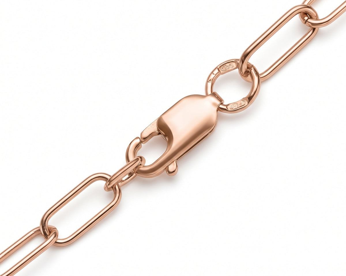 Close-up of a rose gold paperclip chain with a lobster clasp on a white background.
