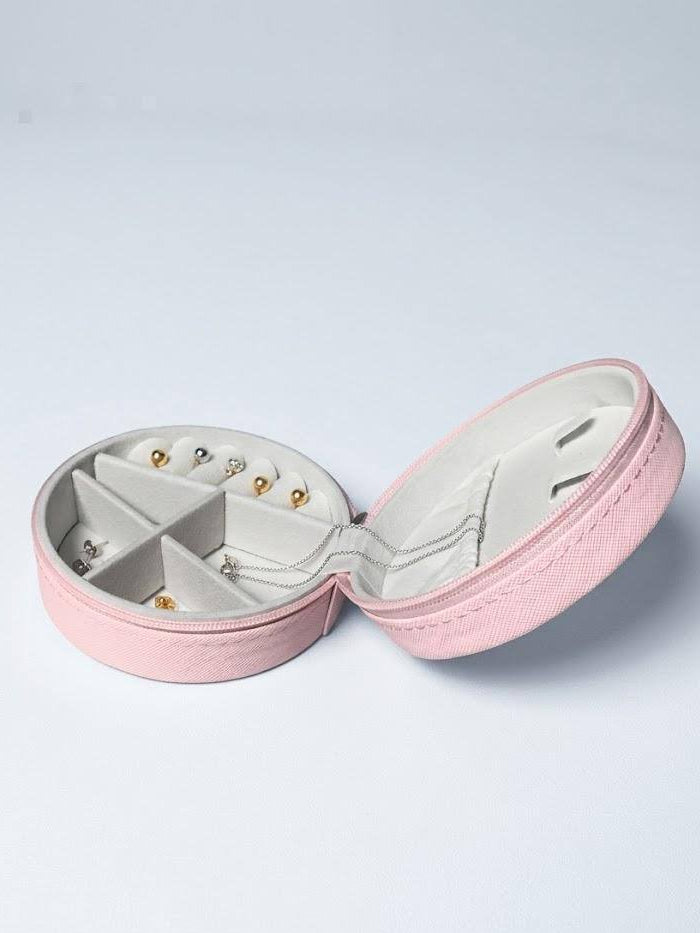 Pink jewelry box with earrings on a light gray background