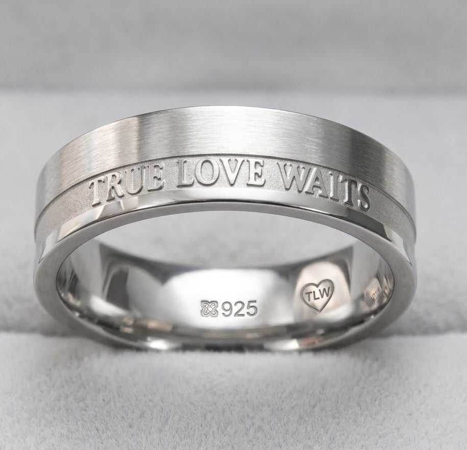 Silver ring with 'True Love Waits' engraving on a gray background