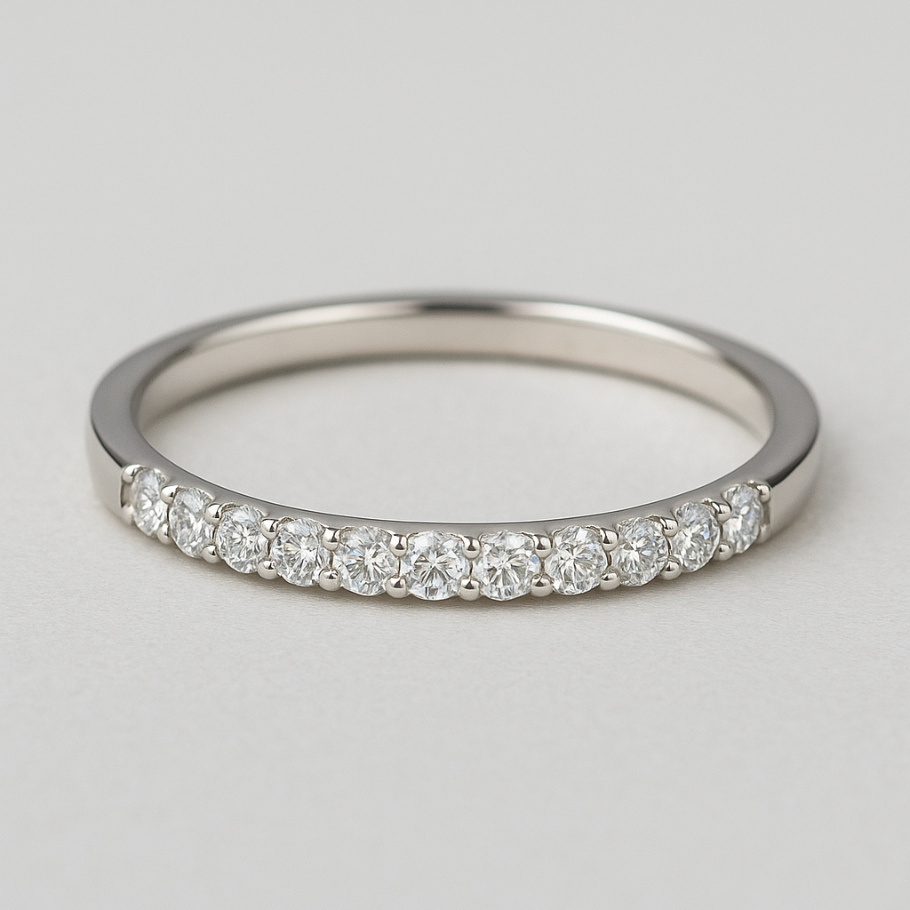 Silver ring with a small moissanite on a light gray background