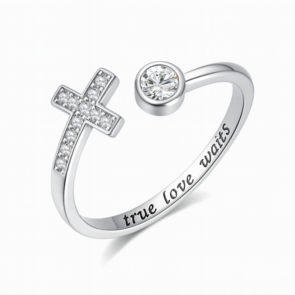 Silver ring with cross design and 'true love waits' engraving on a white background