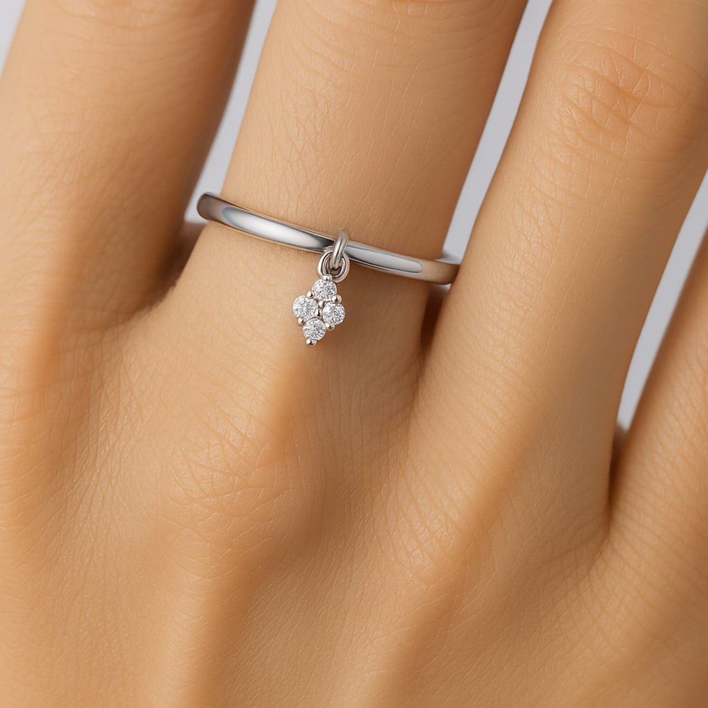 White Gold Diamond Charm Ring with a small diamond charm on a hand against a neutral background